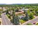 A high-angle aerial view showcases the property's landscaping, solar panels, and surrounding neighborhood with mature trees at 1830 Zang St, Golden, CO 80401