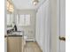Well-lit bathroom with neutral tile, a shower with a white curtain, and classic fixtures at 1830 Zang St, Golden, CO 80401