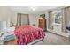 Bright bedroom featuring neutral walls, soft carpet, and a modern TV above a wooden dresser at 1830 Zang St, Golden, CO 80401