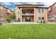 Expansive backyard featuring a covered patio, balcony, lush lawn, and relaxing hot tub, perfect for outdoor living at 10783 Skydance Dr, Highlands Ranch, CO 80126