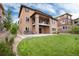 Expansive backyard featuring a covered patio, balcony, hot tub, and well-manicured lawn, perfect for outdoor living at 10783 Skydance Dr, Highlands Ranch, CO 80126