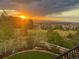 Breathtaking sunset view over the backyard, with mountain views and lush landscaping at 10783 Skydance Dr, Highlands Ranch, CO 80126