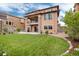 Expansive backyard featuring lush lawn, stone patio, and second story deck, perfect for outdoor living and entertaining at 10783 Skydance Dr, Highlands Ranch, CO 80126