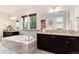Bright bathroom showcasing a soaking tub, dual vanities, tile accents, and natural light at 10783 Skydance Dr, Highlands Ranch, CO 80126