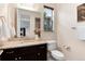 Stylish half-bath features a granite countertop vanity, a window, and a decorative mirror at 10783 Skydance Dr, Highlands Ranch, CO 80126