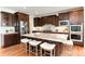 Spacious kitchen features dark wood cabinetry, stainless appliances, granite counters, and island with breakfast bar at 10783 Skydance Dr, Highlands Ranch, CO 80126