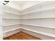 Spacious walk-in pantry with custom shelving provides ample storage and organizational options at 10783 Skydance Dr, Highlands Ranch, CO 80126