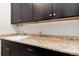 Functional laundry area with undermounted utility sink, ample counter space and dark wood cabinetry at 10783 Skydance Dr, Highlands Ranch, CO 80126
