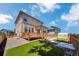 A fenced backyard with a wooden deck, artificial grass, and low maintenance landscaping at 502 Ledge St, Brighton, CO 80603