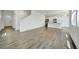 An open concept space with grey wood floors flowing into the kitchen with stainless steel appliances at 502 Ledge St, Brighton, CO 80603