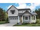 Charming two-story home featuring a covered porch, a two-car garage, and a well-manicured lawn at 8155 Butte Creek Street St, Littleton, CO 80125