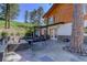 Spacious backyard featuring a stone patio, outdoor seating, and beautiful natural surroundings at 1688 Pine Valley Rd, Evergreen, CO 80439