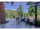 Outdoor patio with seating, surrounded by lush greenery and mountain views, perfect for relaxation at 1688 Pine Valley Rd, Evergreen, CO 80439