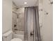 Tiled bathroom with tub and shower combo, featuring a shower curtain and neutral decor at 1688 Pine Valley Rd, Evergreen, CO 80439