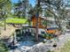 Stunning two-story home with wood and white siding, lush landscaping, and an inviting outdoor area at 1688 Pine Valley Rd, Evergreen, CO 80439