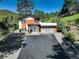 Contemporary home with a large driveway, modern garage door, and a combination of stone, wood, and white accents at 1688 Pine Valley Rd, Evergreen, CO 80439