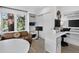 Well-lit home office with desk, comfortable seating, and views of the surrounding trees at 1688 Pine Valley Rd, Evergreen, CO 80439