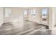 Bright and airy living room featuring gray vinyl plank flooring and a door leading to the outside at 1236 S Algonquian St, Aurora, CO 80018