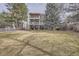 Expansive backyard with lush grass and a white fence, backing up to the home with multiple decks and patio areas at 7157 S Niagara Ct, Centennial, CO 80112