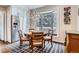 Bright dining area featuring a bay window, hardwood floors, and modern chandelier above a round wooden table at 7157 S Niagara Ct, Centennial, CO 80112