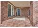 Charming covered front porch with brick flooring and detailed brickwork at 7157 S Niagara Ct, Centennial, CO 80112