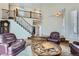 Spacious living room featuring a grand staircase and luxurious leather armchairs at 7157 S Niagara Ct, Centennial, CO 80112