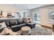 Open concept living room with a dark leather sofa, rug, and sliding doors to the deck, and connected to the kitchen at 7157 S Niagara Ct, Centennial, CO 80112