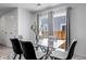 Bright dining area with a modern glass table, comfortable seating, and natural light from large windows at 28330 E 6Th Pl, Watkins, CO 80137