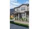 Inviting townhome showcasing a covered porch with decorative plants, neutral siding, and stone landscaping at 28330 E 6Th Pl, Watkins, CO 80137
