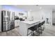 Contemporary kitchen featuring a large island with bar stools, stainless appliances, and white subway tile at 28330 E 6Th Pl, Watkins, CO 80137