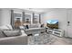 Comfortable living room featuring plush seating, a sleek glass table, and a large TV for entertainment at 28330 E 6Th Pl, Watkins, CO 80137