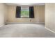 The vacant bedroom features neutral walls, carpet, and a large window for natural light at 3418 Elk Ct, Broomfield, CO 80020