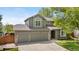 Charming two-story home featuring a well-manicured lawn, mature tree, and a two-car garage at 3418 Elk Ct, Broomfield, CO 80020
