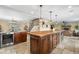 Kitchen island with stone countertop and dark wood cabinets is perfect for meal preparation and entertaining at 3418 Elk Ct, Broomfield, CO 80020