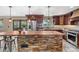 Gourmet kitchen with custom wood cabinets, stone island, and pendant lighting at 3418 Elk Ct, Broomfield, CO 80020