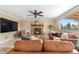 Inviting living room featuring a fireplace, comfortable leather seating, and a ceiling fan for added comfort at 3418 Elk Ct, Broomfield, CO 80020