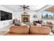 Cozy living room boasting a brick fireplace, leather seating, and a ceiling fan at 3418 Elk Ct, Broomfield, CO 80020