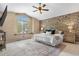 Bright main bedroom with vaulted ceiling, stone accent wall, and large window at 3418 Elk Ct, Broomfield, CO 80020