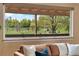 Living room view of a scenic outdoor area with lush greenery and a clear blue sky enhancing the home's appeal at 3418 Elk Ct, Broomfield, CO 80020