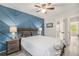 Cozy bedroom featuring a blue accent wall, wooden furniture, and a ceiling fan for added comfort at 9519 W Coal Mine Ave # F, Littleton, CO 80123