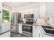 Modern kitchen with white cabinets, stainless steel appliances, and black countertops at 9519 W Coal Mine Ave # F, Littleton, CO 80123