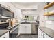 Bright kitchen featuring white cabinets, stainless steel appliances, and an open layout at 9519 W Coal Mine Ave # F, Littleton, CO 80123