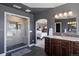 Modern bathroom with a glass-enclosed shower, dark vanity, and access to the main bedroom at 4605 Tierra Alta Dr, Castle Rock, CO 80104