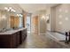 Well-lit bathroom with double sinks, granite countertops, soaking tub, and tile flooring at 4605 Tierra Alta Dr, Castle Rock, CO 80104