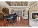 Elegant foyer with grand staircase, piano, fireplace, and gleaming hardwood floors creates a welcoming atmosphere at 4605 Tierra Alta Dr, Castle Rock, CO 80104