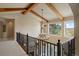 Spacious upper hallway featuring wood beams, iron railing, and a modern chandelier at 4605 Tierra Alta Dr, Castle Rock, CO 80104