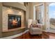Cozy living room nook featuring a stone-accented fireplace and a comfortable armchair for relaxation at 4605 Tierra Alta Dr, Castle Rock, CO 80104