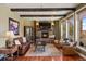 Cozy living room with comfortable seating, stone fireplace, and wood beam ceilings for a rustic feel at 4605 Tierra Alta Dr, Castle Rock, CO 80104