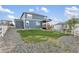Spacious backyard with grass and gravel, white fence, and a charming covered deck area at 2248 Rosette Ln, Castle Rock, CO 80104