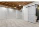 Finished basement featuring a sliding barn door, wood plank ceiling, and white shiplap accent walls at 2248 Rosette Ln, Castle Rock, CO 80104